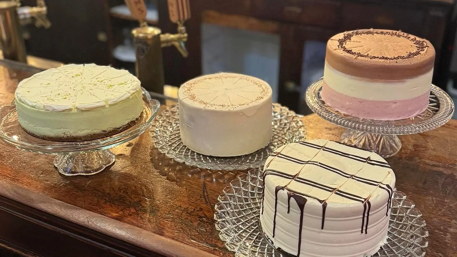 Four house-made layer cakes displayed on glass stands at Graham’s Store