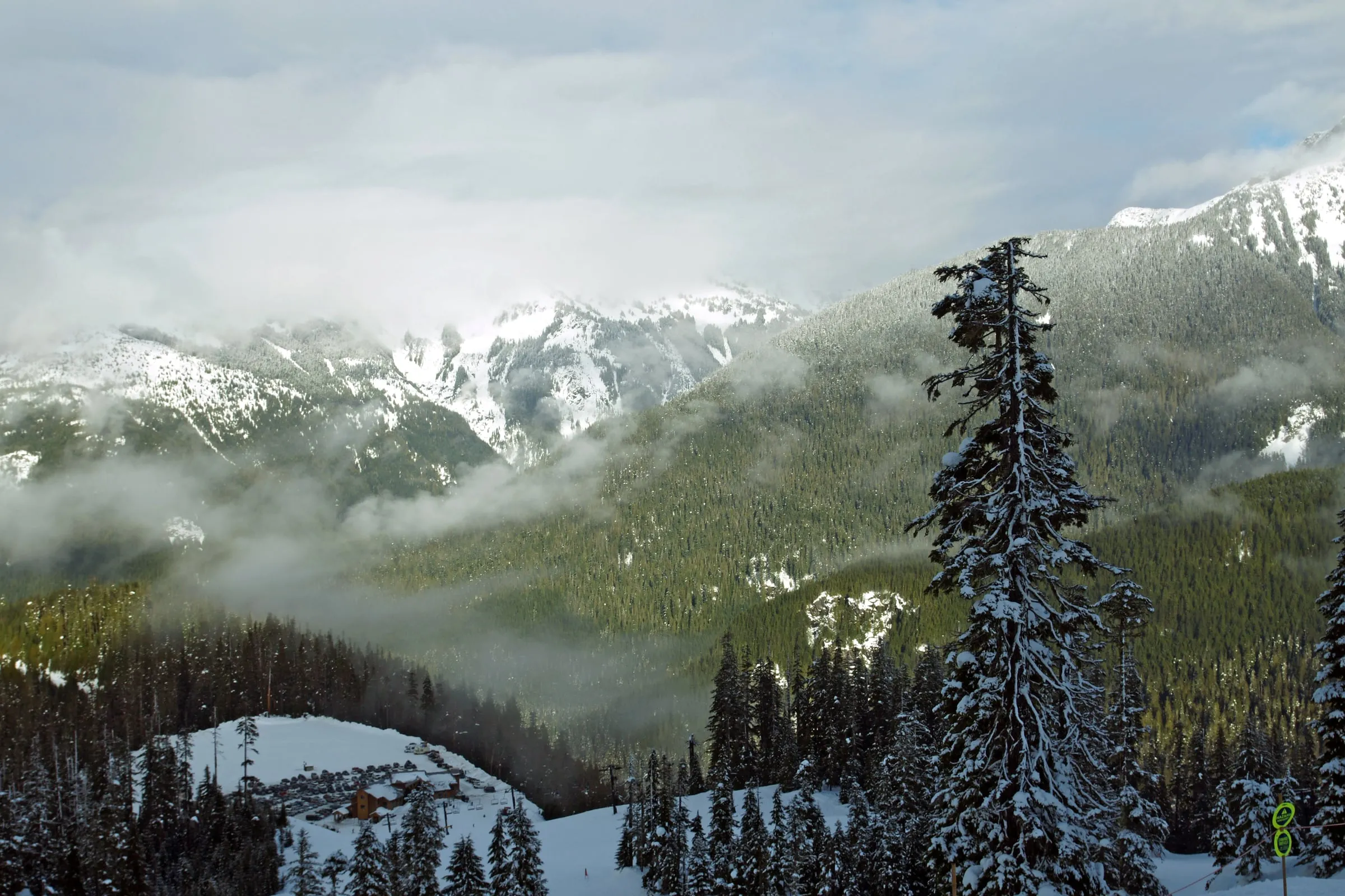 Snow-covered base area lodge and parking lot at Mt. Baker Ski Area seen from above in winter