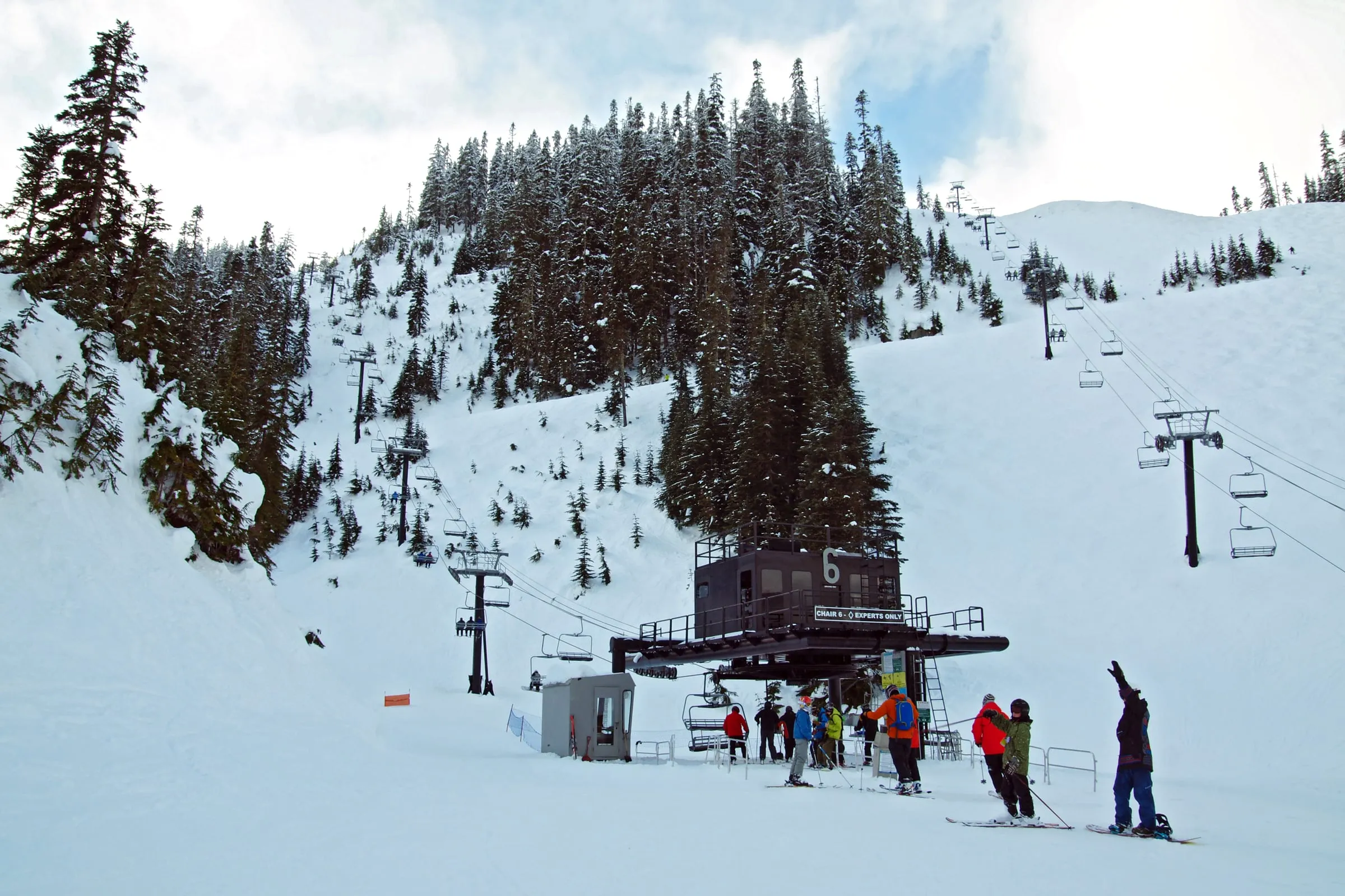 Skiers and snowboarders loading a chairlift at the base of an experts-only run at Mt. Baker Ski Area