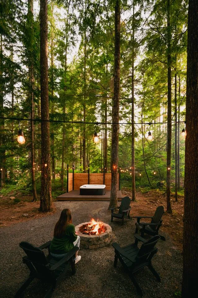 Hot tub on the cedar deck surrounded by tall evergreens