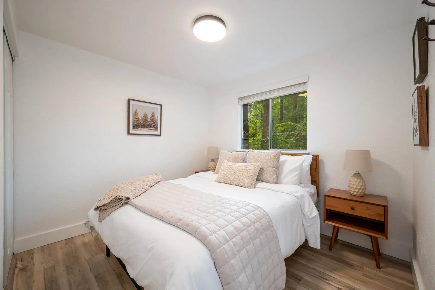 Bedroom 1 with queen bed and forest-view window