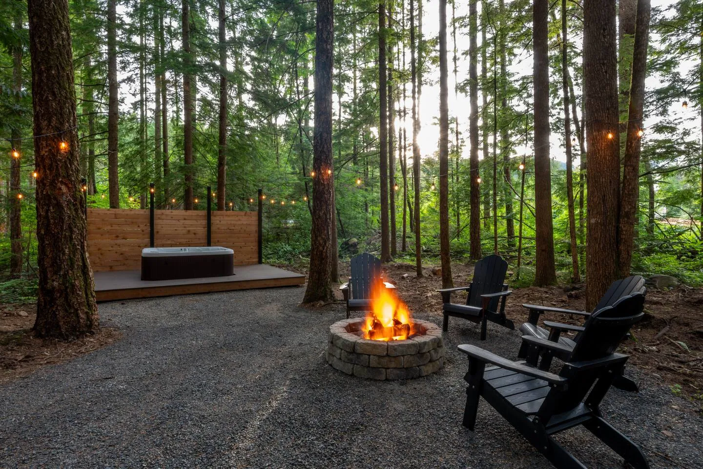 Fire pit burning beside the cedar hot tub deck