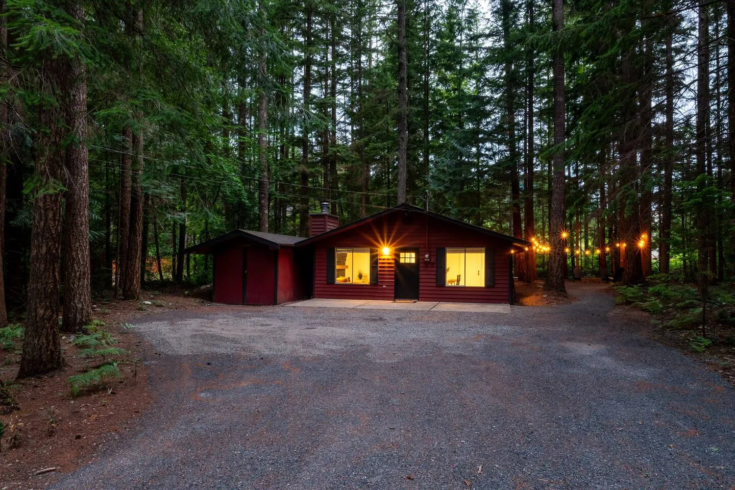 Red cabin lit up at night under the stars