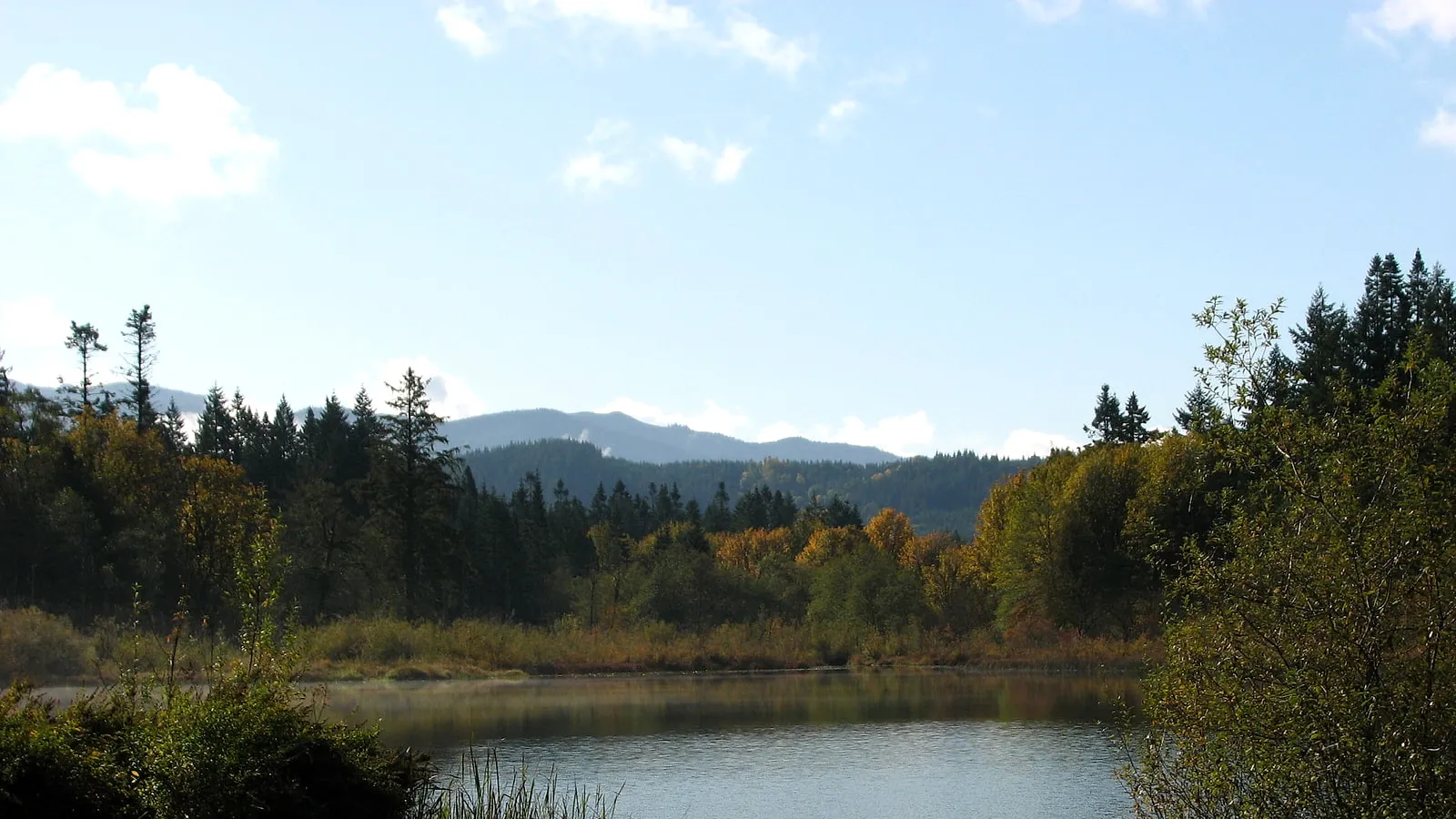 Silver Lake on a calm fall morning, forested hills behind