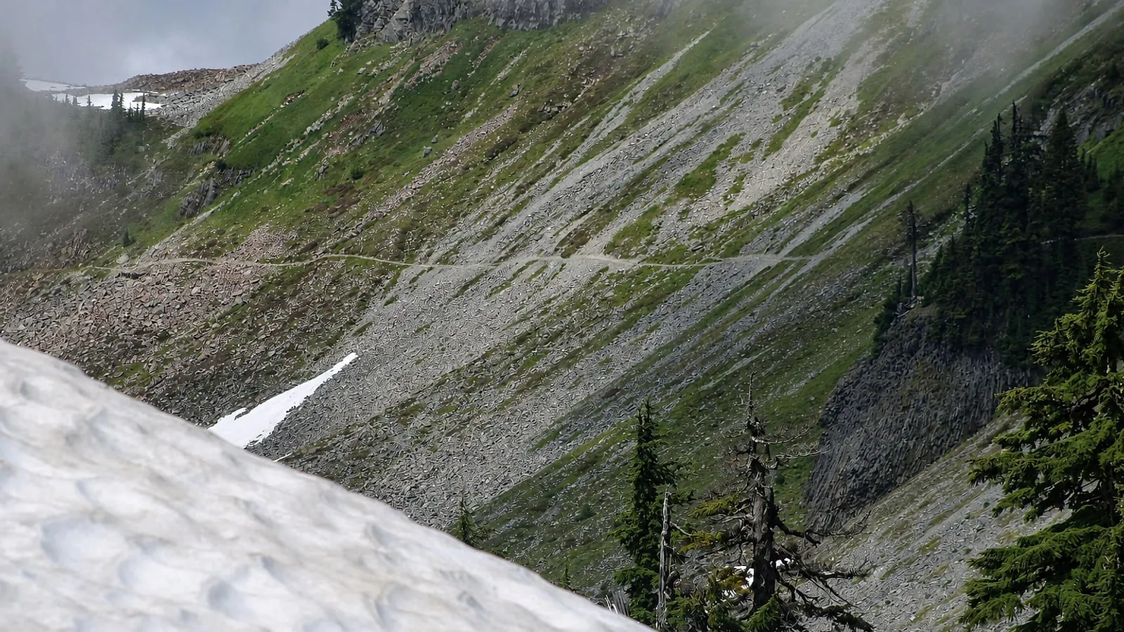 The narrow Table Mountain trail traversing a steep rocky alpine slope above Artist Point